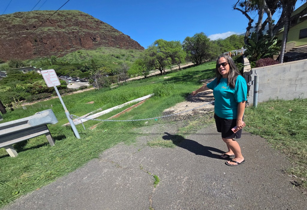 Lena Spain-Suzuki points toward the property along Farrington Highway where the Waiʻanae Moku Kupuna Council hopes to develop a kūpuna kauhale.