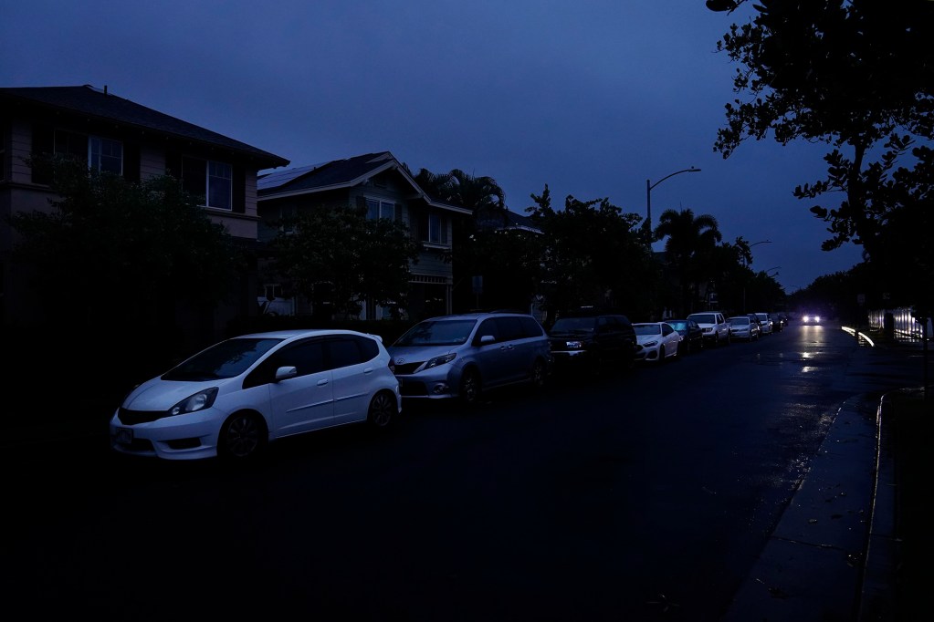 This photo shows houses and street lights in the dark because of a power outage in the Ocean Pointe neighborhood Saturday, March 14, 2026, in ʻEwa Beach, Hawai‘i. A Kona Low storm has put the entire state of Hawaii on its heels with power and communication outages and widespread flooding.