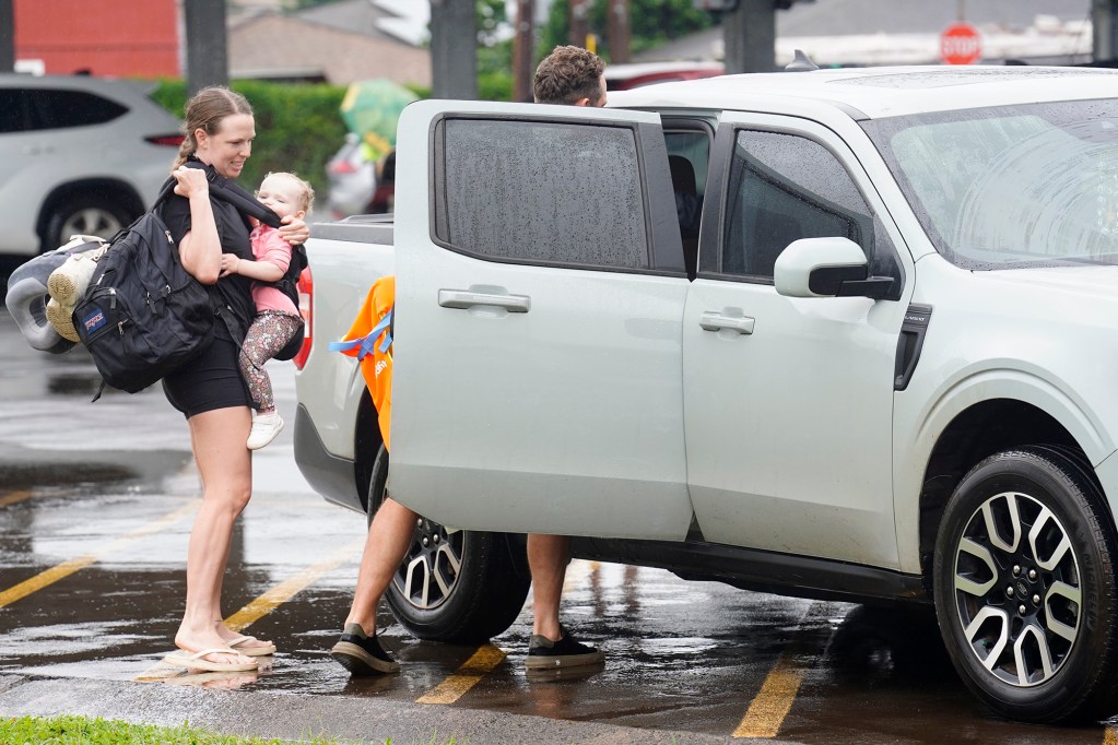 Charlotte and Alana Hayward get a ride to a friends house after their Waialua home flooded on the North Shore  Friday, March 12, 2026, in Wahiawā. (Kevin Fujii/Civil Beat/2026)