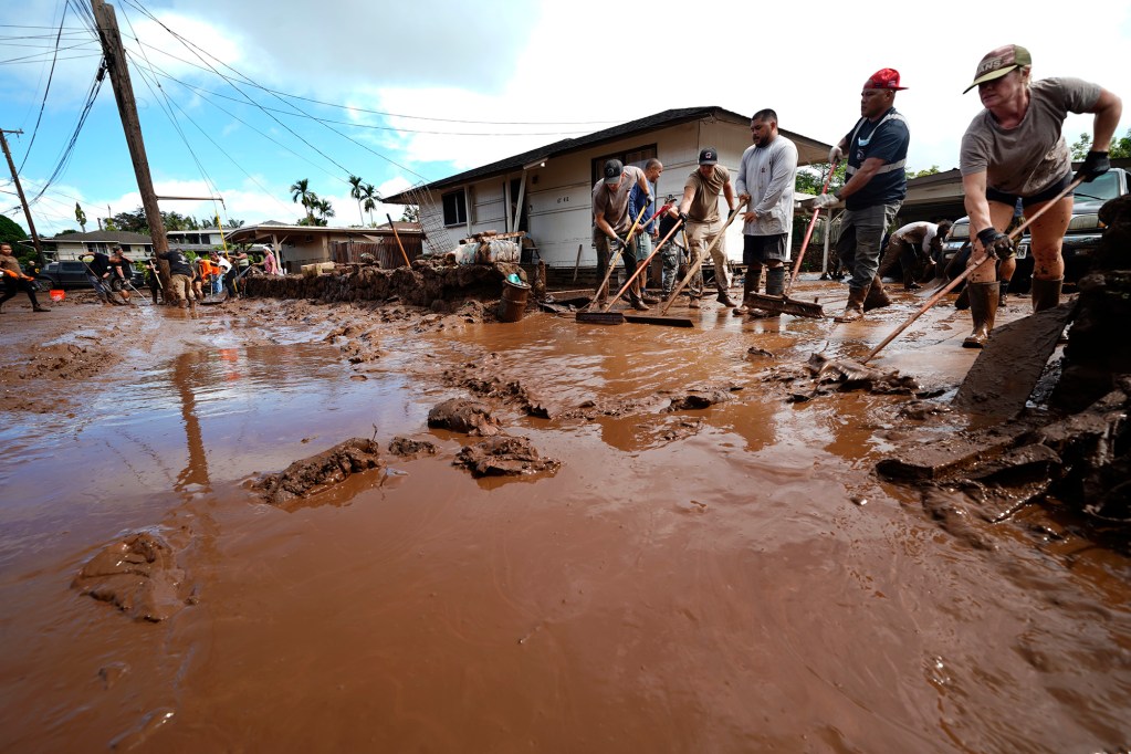 Volunteers push out mud at a Haona Street home Monday, March 23, 2026, in Waialua. A second Kona low storm brought heavy rain after the previous week’s downpour and high winds. (Kevin Fujii/Civil Beat/2026)