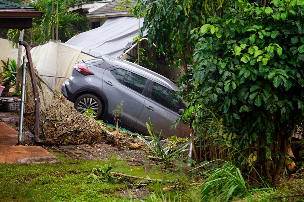 A car rests where flood waters deposited it near Waialua Beach Road Monday, March 23, 2026, in Waialua. A second Kona low storm brought heavy rain after the previous week’s downpour and high winds. (Kevin Fujii/Civil Beat/2026)