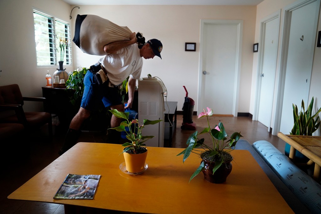 Ka‘ala Healing Arts building manager and tenant Jeff Ramos clears out some of his belongings Wednesday, March 25, 2026, in Waialua. The building is next to the Otake Bridge which flooded during the second Kona Low storm. (Kevin Fujii/Civil Beat/2026)