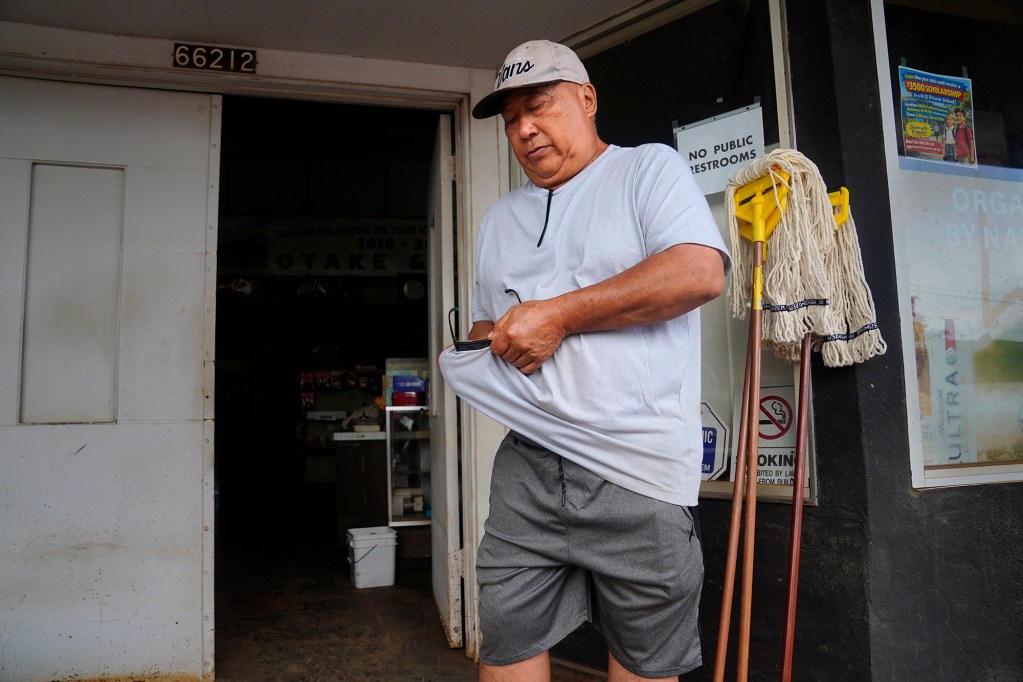 Wendell Toki who owns Otake Camp property behind the Otake Store cleans his sunglasses Wednesday, March 25, 2026, in Waialua. The former plantation residential neighborhood received damage from the second Kona Low storm. (Kevin Fujii/Civil Beat/2026)