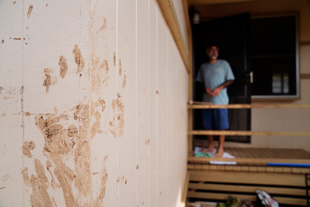 Muddy handprints on Rafe Maldonado’s home are reminders of the work he and volunteers have been putting into recovery Friday, March 27, 2026, in Waialua. Maldonado lives on Haona Street next to the Kaukonahua Stream which flooded his home and neighbors during the Kona Low storm. (Kevin Fujii/Civil Beat/2026)