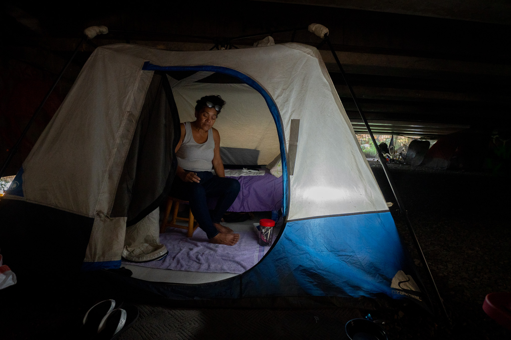 Kim Mathias sits in the tent she erected under a bridge near the Ke'ehi Transfer Station. Mathias, 55, has been at her current location for almost one year. Originally from Hilo, Mathias suffered three strokes and has mild residual weakness and memory problems, she said.