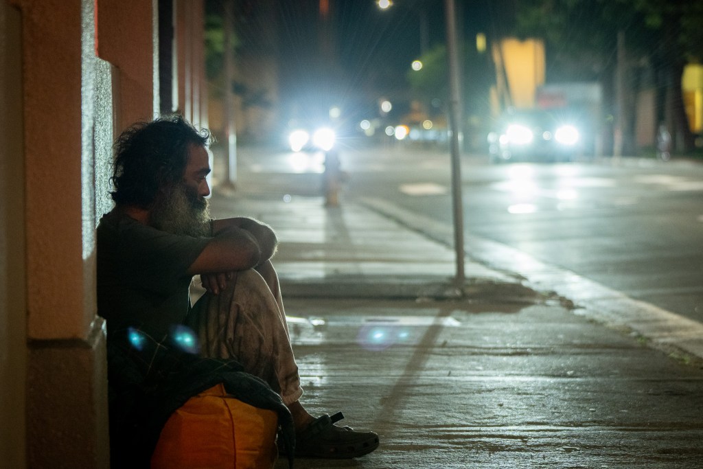 Joshua Makaya, 40, sits with his belongings on Alakea St in the Honolulu business district.