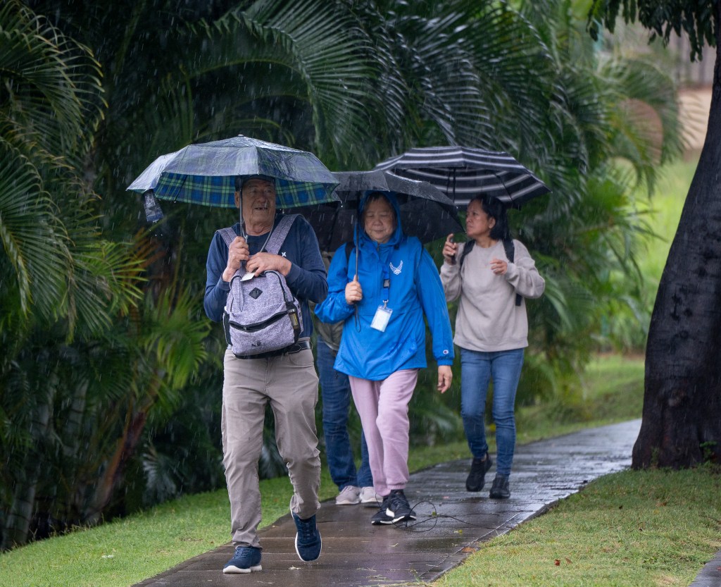 Pedestrians with umbrellas unfurled walked along Managers Drive in Waipahu March 12, 2026. A slow-moving storm is expected to strike the Hawaiian islands tonight. (Craig Fujii/Civil Beat/2026)