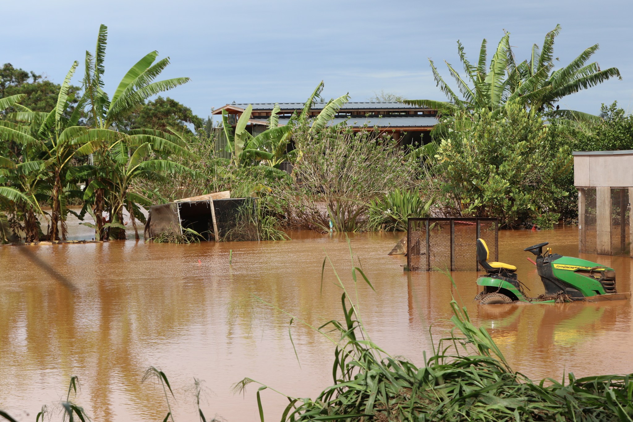 A lawmower sits deep in water after flooding consumed Farrington Highway and crashed onto plots of small farms, which were once owned by Dole. (Thomas Heaton/Civil Beat/2026)
