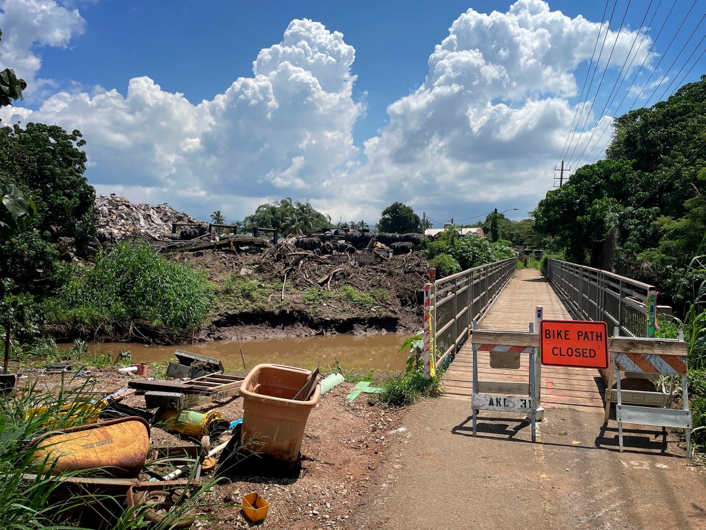 The Pearl Harbor Bike Path bridge over the Waiawa Stream is closed Tuesday, April 21, 2026, in Pearl City. Remnants of the homeless encampment on the ʻEwa side of the stream lie exposed on the banks. (Kevin Fujii/Civil Beat/2026)