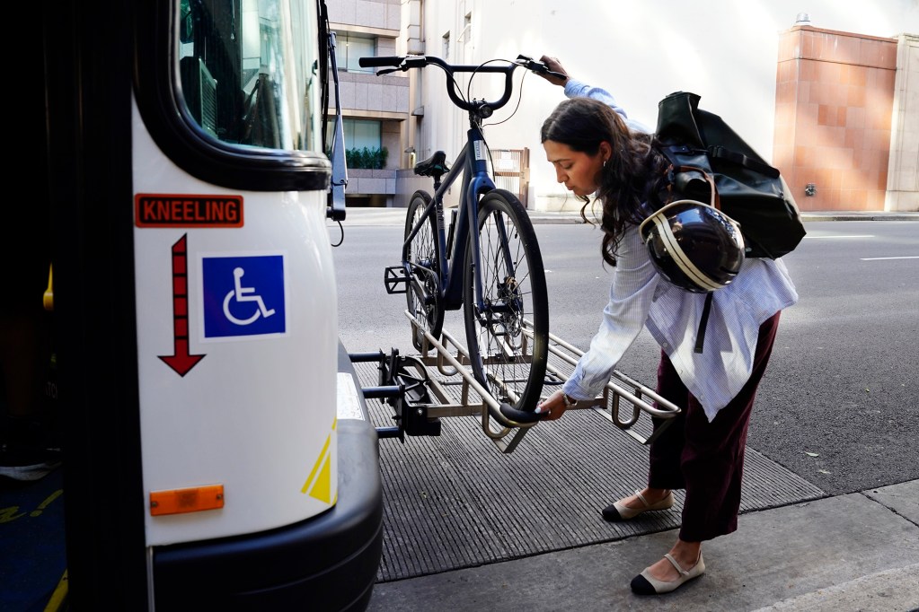 Hawai‘i Bicycling League Board of Directors president Samantha Lara puts her e-bike on TheBus Wednesday, May 13, 2026, in Honolulu. She’s commuting to work in Kāneʻohe. (Kevin Fujii/Civil Beat/2026)