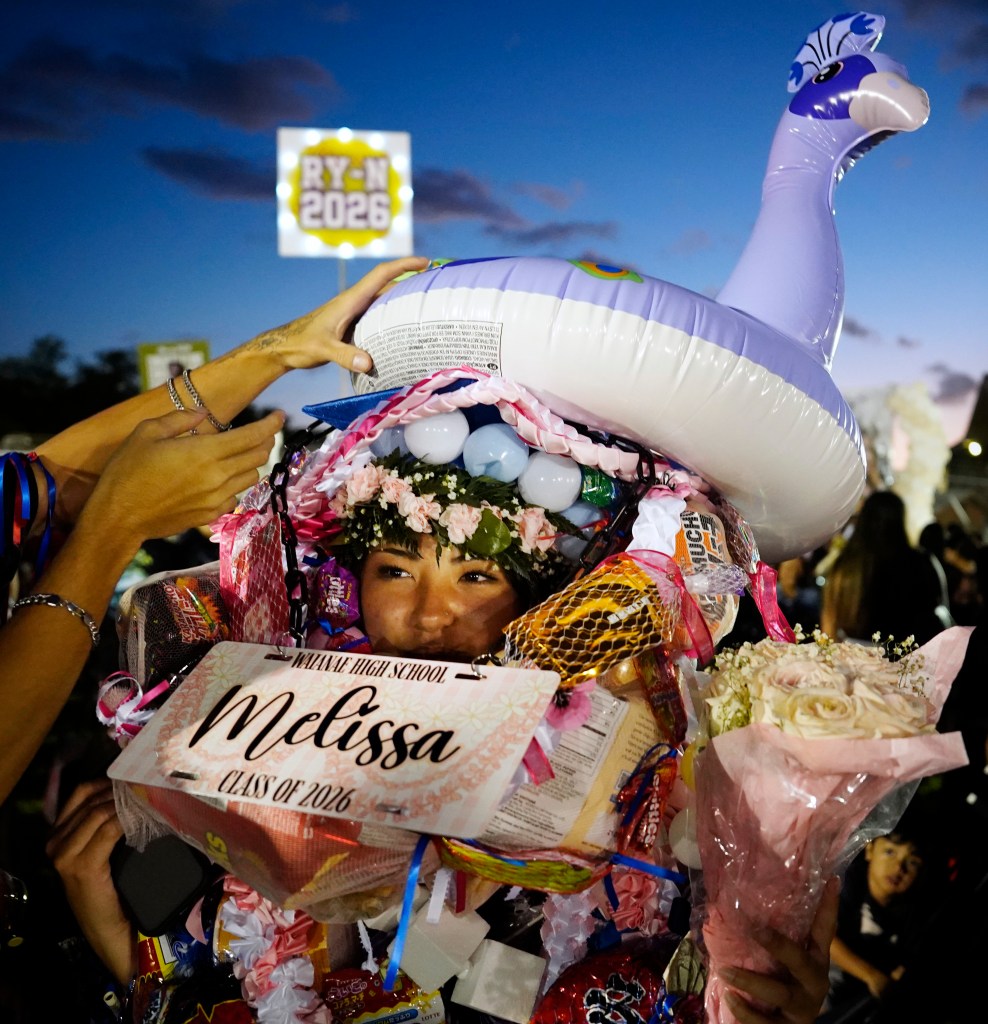 Anyone seen Waiʻanae High School graduate Melissa Taira? She gets buried under lei and gifts after her commencement ceremony Friday, May 22, 2026, in Waiʻanae. (Kevin Fujii/Civil Beat/2026)