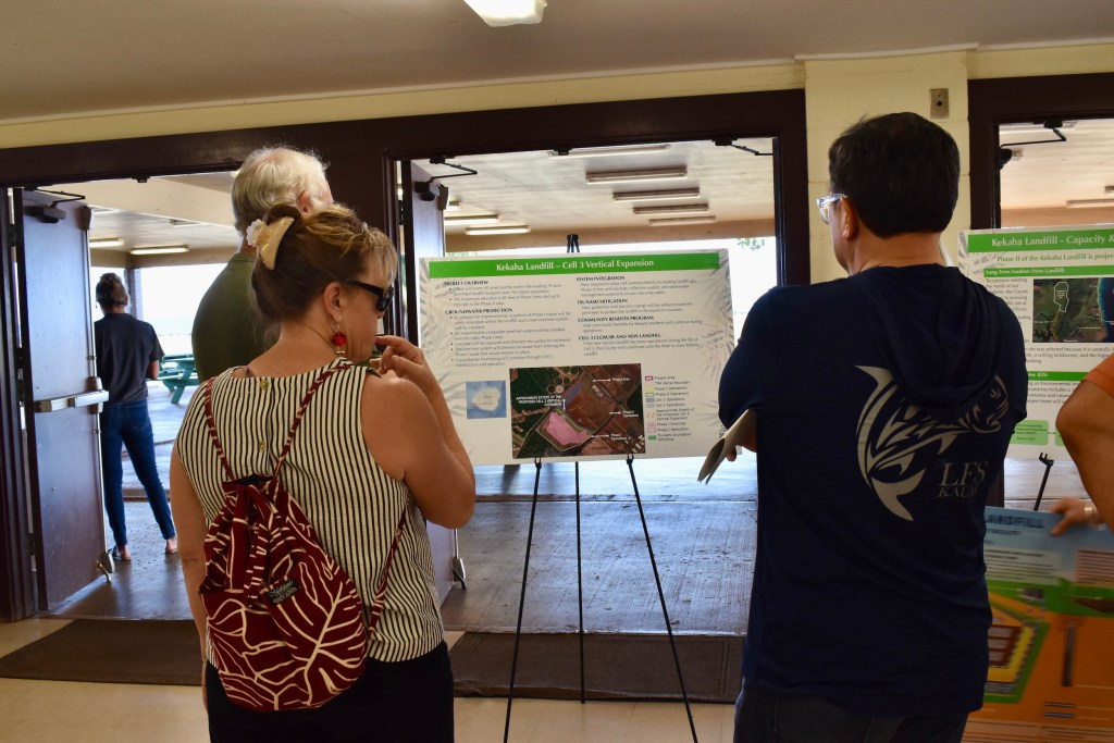 Three Kaua‘i community members read a poster board about the Kekaha landfill's Cell 3 Vertical Expansion project.