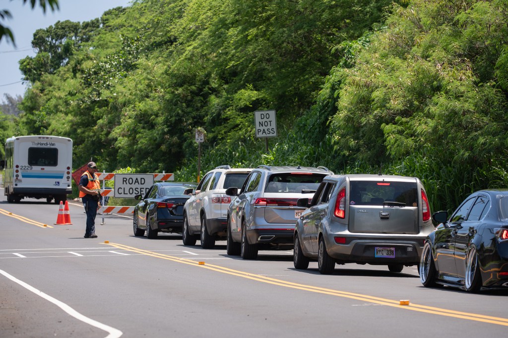 Vehicles are turned around on the Haleʻiwa side of Waimea Bay as crews worked to place safety netting on the 230 foot hill above Waimea Bay May 17, 2026. Buses and Handivan were allowed through at intervals. (Craig Fujii/Civil Beat/2026)