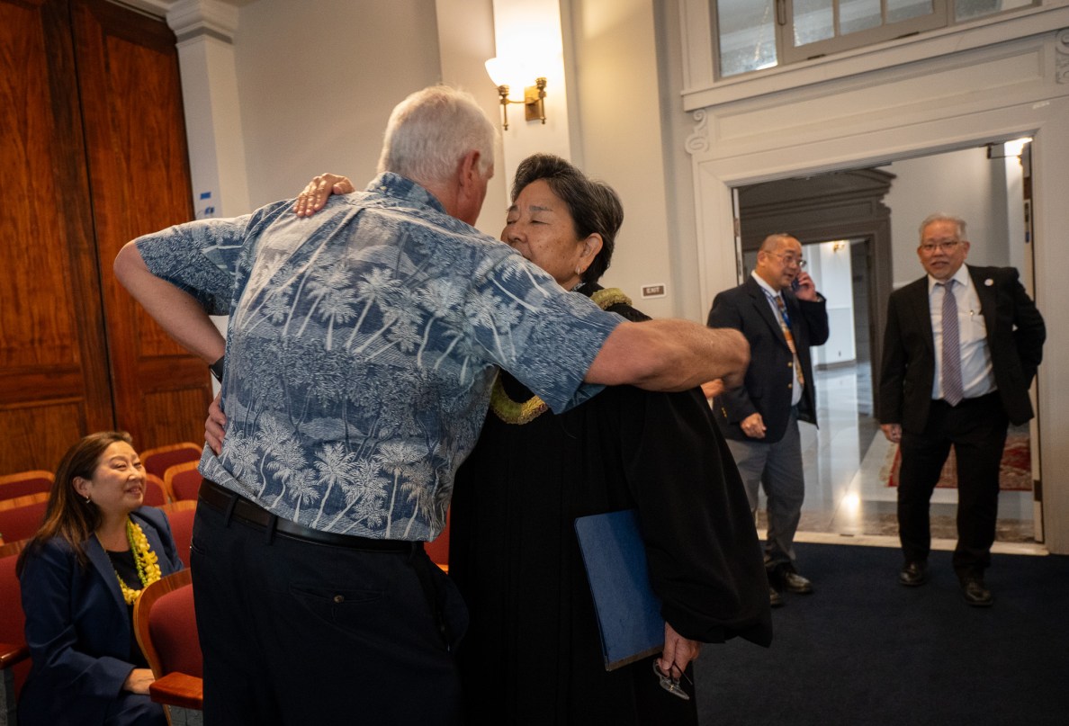 Retired Supreme Court Chief Justice Mark Recktenwald, left, shares a hug with current Associate Justice Lisa Ginoza prior to Law Day celebrations at Ali'iolani Hale May 1, 2026. (Craig Fujii/Civil Beat/2026)