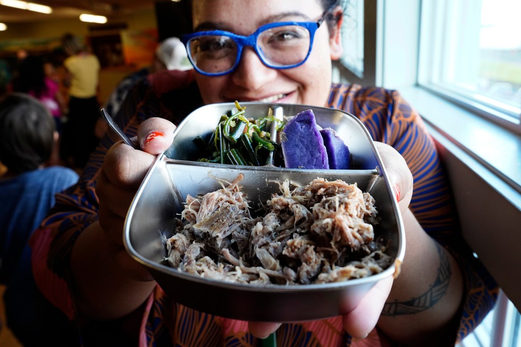 Zero Waste Hawaiʻi Island Cultural Advisor Ku‘ulei Keawekane shows off her dinner in a Ho‘i Returnable Dish during their open house Tuesday, June 30, 2026, in Hilo. Zero Waste Hawaiʻi Island and Perpetual are two non-profits working to get food companies to begin using the re-useable restaurant food-grade containers. (Kevin Fujii/Civil Beat/2026)