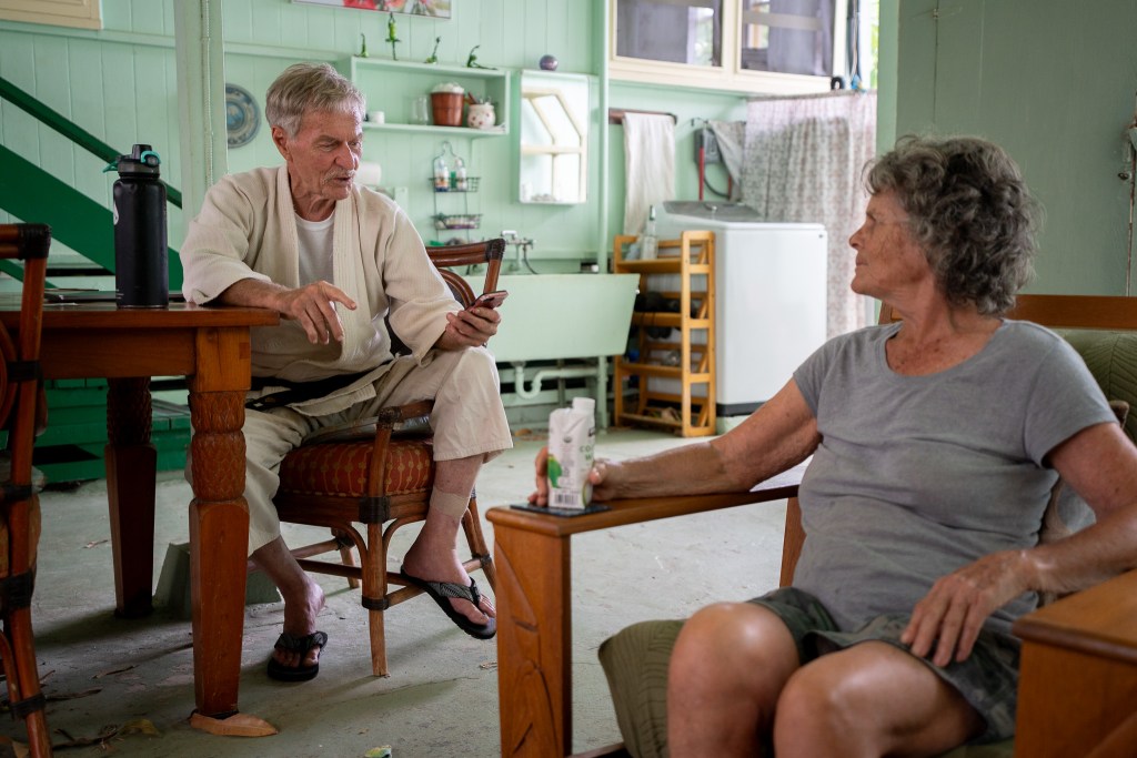 Xavier Staub, left, reads a text from state Rep. Chris Muraoka as his partner Louise Tremblay listens at their Mākaha home June 10, 2026. Staub was attacked by his neighbor's dogs March 27, 2026. (Craig Fujii/Civil Beat/2026)