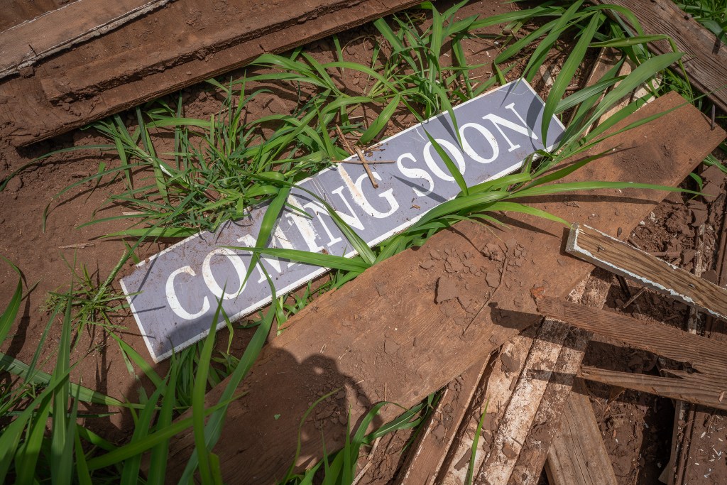 A sign sits amid flood debris on a Wailua farm June 1, 2026. Area farmers are working to clear their land of debris and sediment from the Kona low storms in March. (Craig Fujii/Civil Beat/2026)
