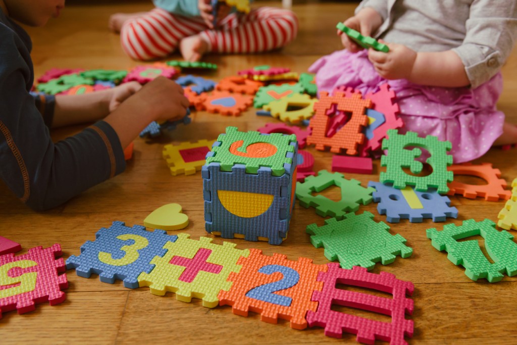kids playing with number puzzle, education concept