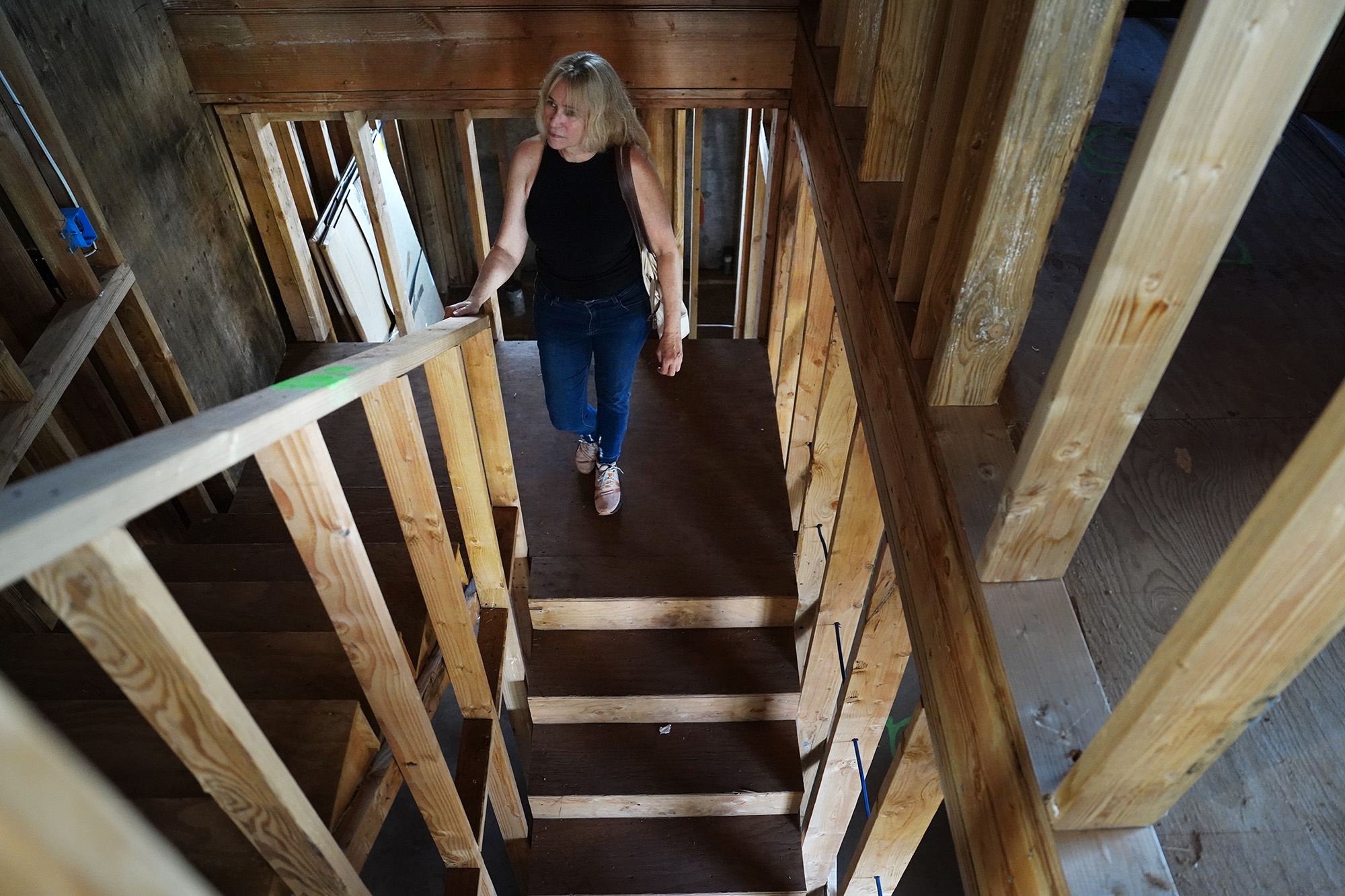 Krista Woodward stops on the landing of her stalled home reconstruction Wednesday, July 1, 2026, in Lahaina. Woodward’s contractor allegedly scammed her and others rebuilding in Lahaina. (Kevin Fujii/Civil Beat/2026)