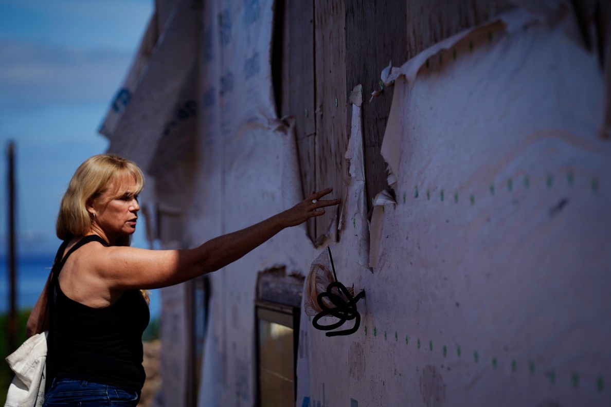 Krista Woodward points out below-standard workmanship at her stalled home reconstruction Wednesday, July 1, 2026, in Lahaina. Woodward’s contractor allegedly scammed her and others rebuilding in Lahaina. (Kevin Fujii/Civil Beat/2026)