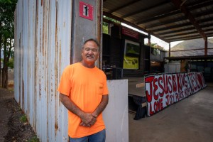 Pastor Kimo Matsumoto stands next to his pulpit on the grounds of Powerhouse Church July 15, 2026. The grounds flooded during the March Kona low storms, forcing residents to fend for themselves.  (Craig Fujii/Civil Beat/2026)