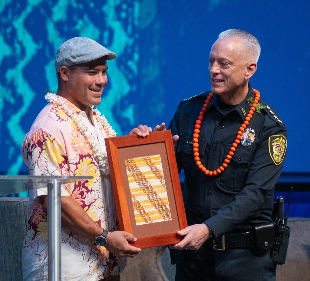 Joey Cadiz is presented with an award from HPD Chief David Lazar at the 2026 Native Hawaiʻian Convention at Blaisdell Center July 22, 2026. Cadiz was noted for his actions during the March Kona low storms. (Craig Fujii/Civil Beat/2026)