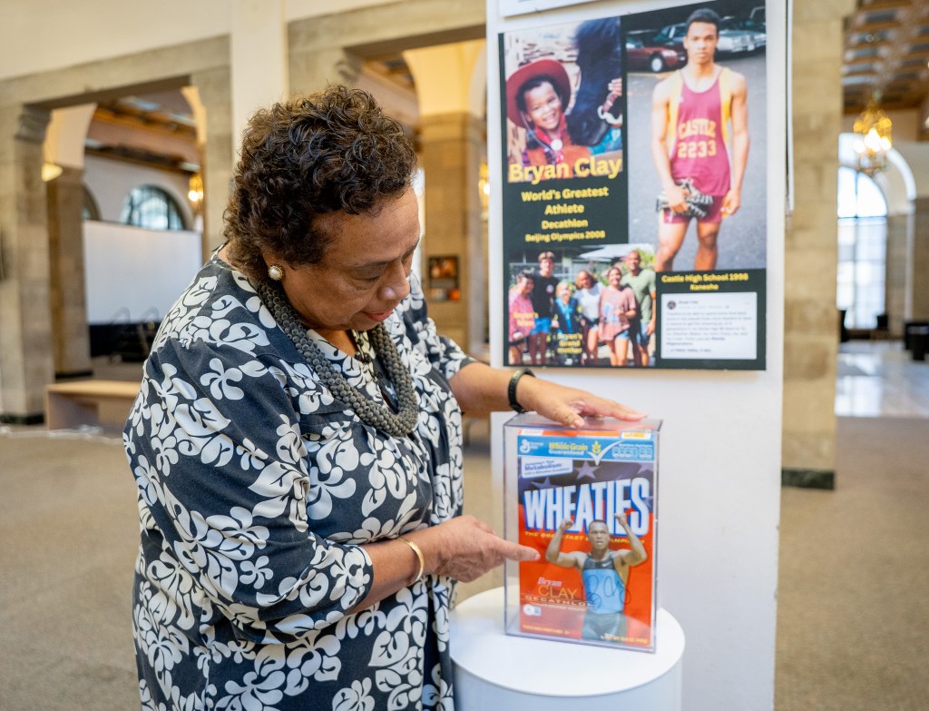Gloria Borland shows an autographed Wheaties box autographed by Olympic decathlon champion Bryan Clay, who attended Castle High School.  Borland is the driving force behind the Hawaiʻi Inspiration Museum at the old HECO building in Honolulu, where she was photographed July 22, 2026. (Craig Fujii/Civil Beat/2026)