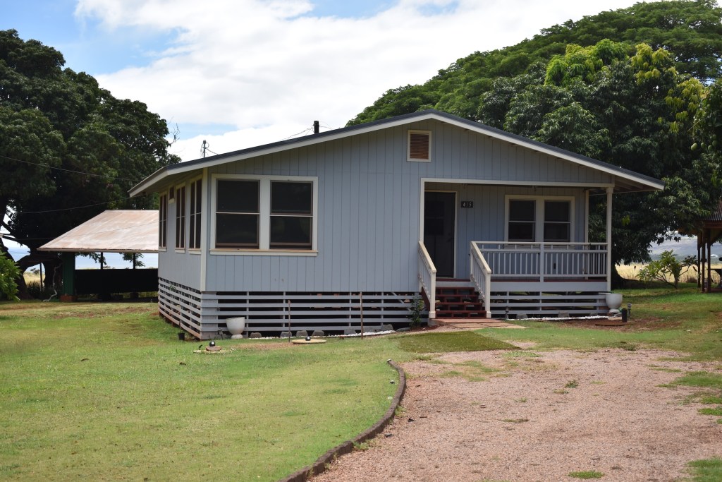 A light blue home on an elevated foundation in Kaumakani Village on Kaua‘i.