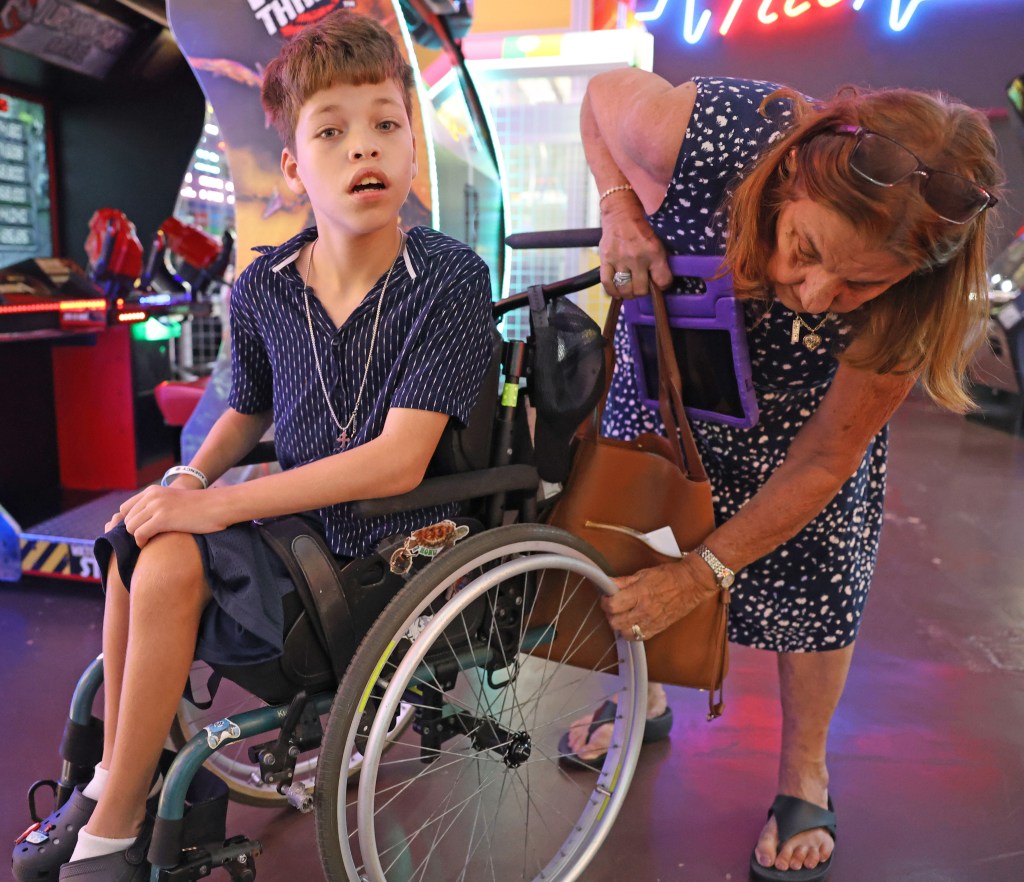 Linda Eblacas adjusts the wheel of her great-grandson Cylas Eblacas' wheelchair at Tilt arcade inside Prince Kūhiō Plaza in Hilo. The wheelchair replaced an earlier one after its frame was damaged. Photo by Tim Wright / newsphotoshawaii.com