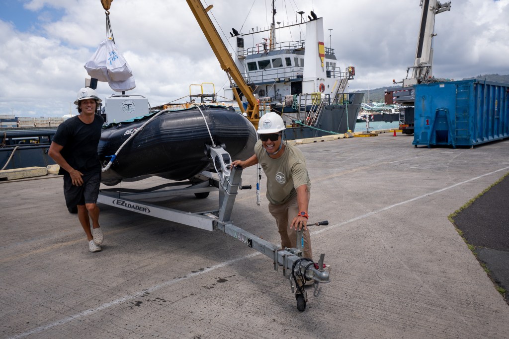 James Morioka, right, and Ossian Nichols (cq) move a rigid inflatable boat at Pier 34 August 28, 2026. The Papahānaumokuākea Marine Debris Project unloaded gear and collected debris from a mission to Papahānaumokuākea. (Craig Fujii/Civil Beat/2026)