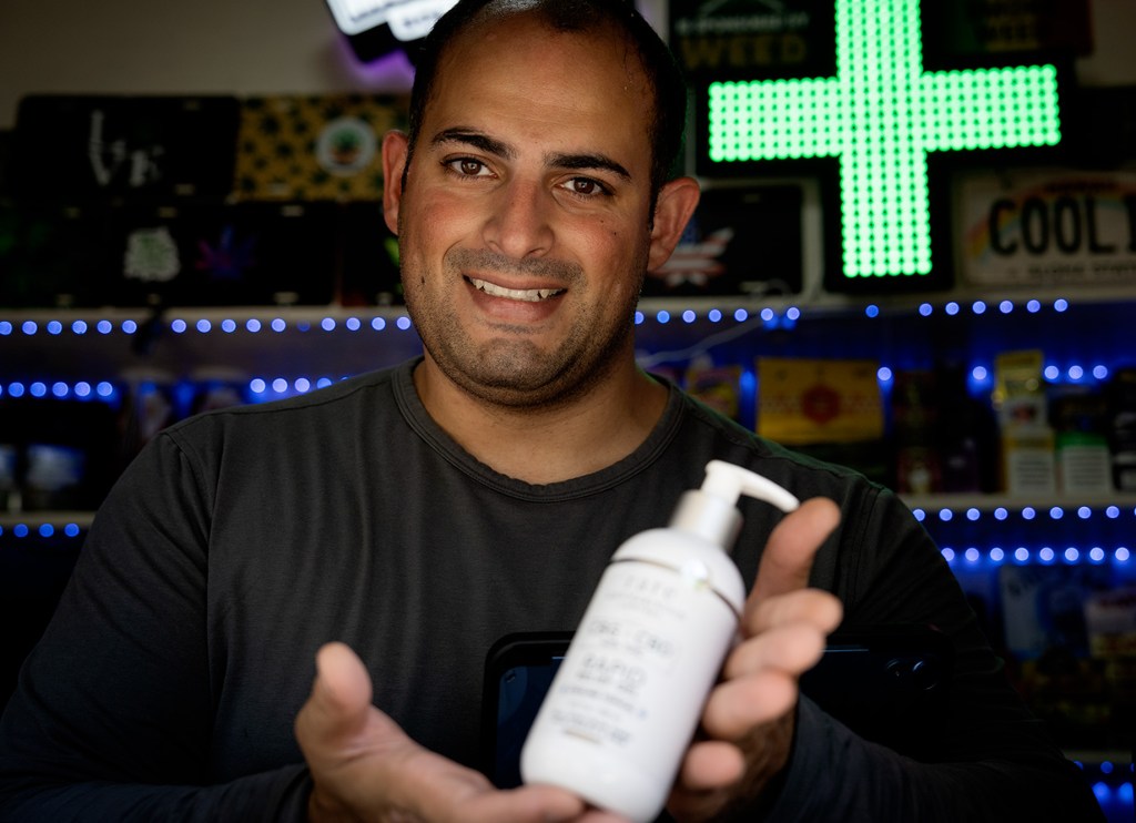 Lance Alyas of Oahu Dispensary and Provisions holds legal a CBD product he is allowed to sell Tuesday, Aug. 11, 2026, at his dispensary in Honolulu. (Kevin Fujii/Civil Beat/2026)