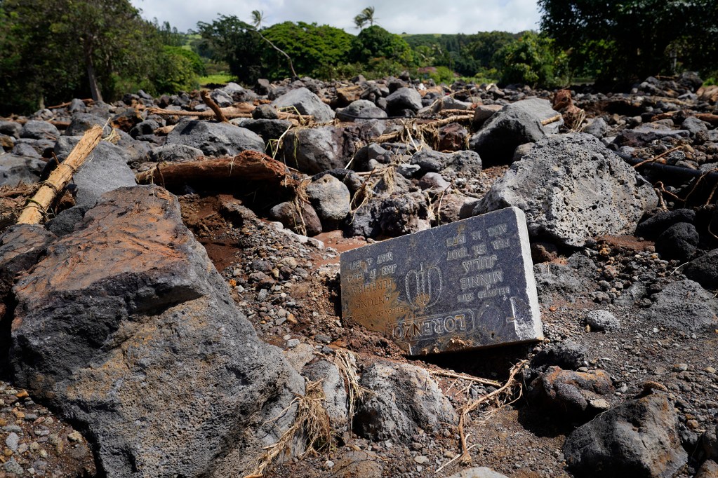 A headstone from the Nāʻālehu Cemetery lies among rubble Tuesday, Aug. 18, 2026, on Hawaiʻi Island. Hurricane Lala made a close pass to the South Point of the Big Island Saturday. (Kevin Fujii/Civil Beat/2026)