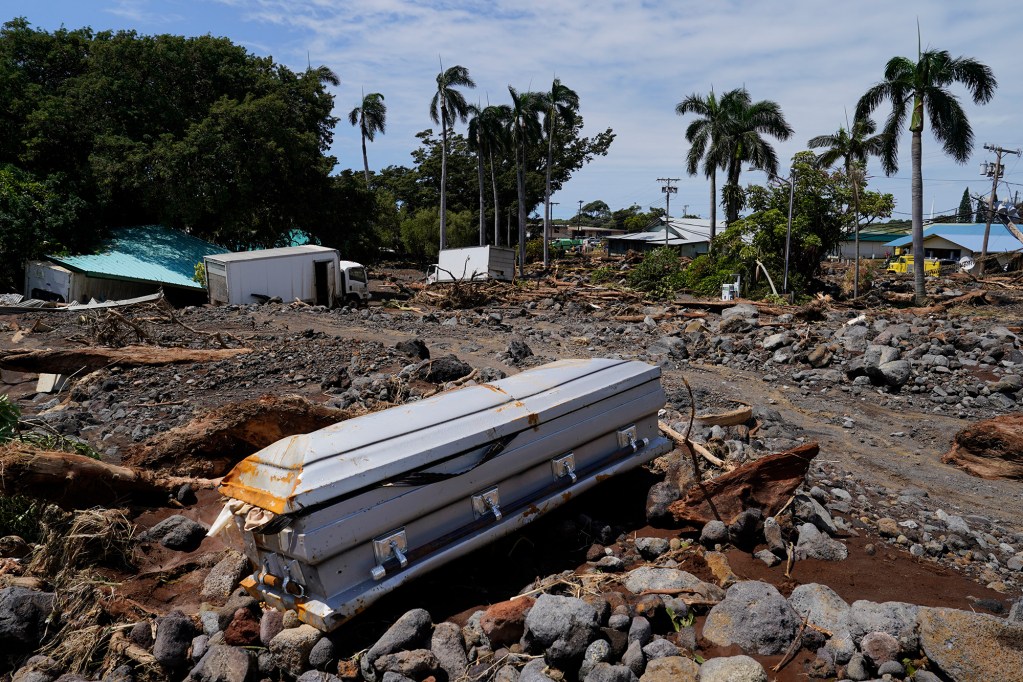 A casket washed down from Nāʻālehu Cemetery lies among rubble Tuesday, Aug. 18, 2026, on Hawaiʻi Island. Hurricane Lala made a close pass to the South Point of the Big Island Saturday. (Kevin Fujii/Civil Beat/2026)
