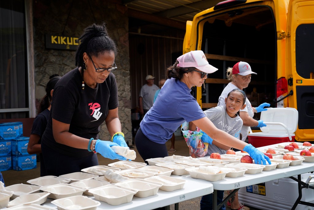 Community volunteers plate food from World Relief Kitchen at the Nāʻālehu Hongwanji Mission Tuesday, Aug. 18, 2026, on Hawaiʻi Island. Hurricane Lala made a close pass to the South Point of the Big Island Saturday. (Kevin Fujii/Civil Beat/2026)