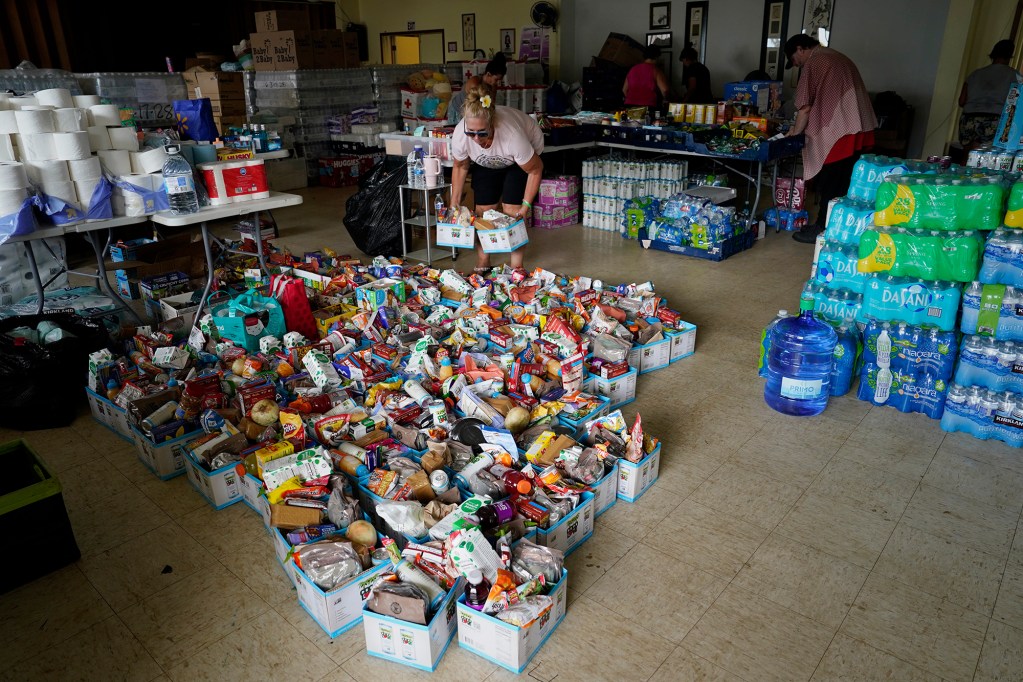 Community volunteers gather items at the Nāʻālehu Hongwanji Mission Tuesday, Aug. 18, 2026, on Hawaiʻi Island. Hurricane Lala made a close pass to the South Point of the Big Island Saturday. (Kevin Fujii/Civil Beat/2026)