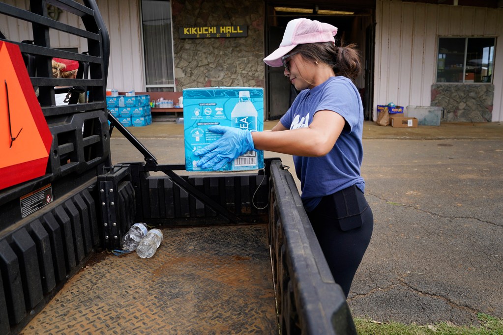 Community volunteer Jaeneise Sales of Nāʻālehu places water in an ATV at the Nāʻālehu Hongwanji Mission Tuesday, Aug. 18, 2026, on Hawaiʻi Island. Hurricane Lala made a close pass to the South Point of the Big Island Saturday. (Kevin Fujii/Civil Beat/2026)