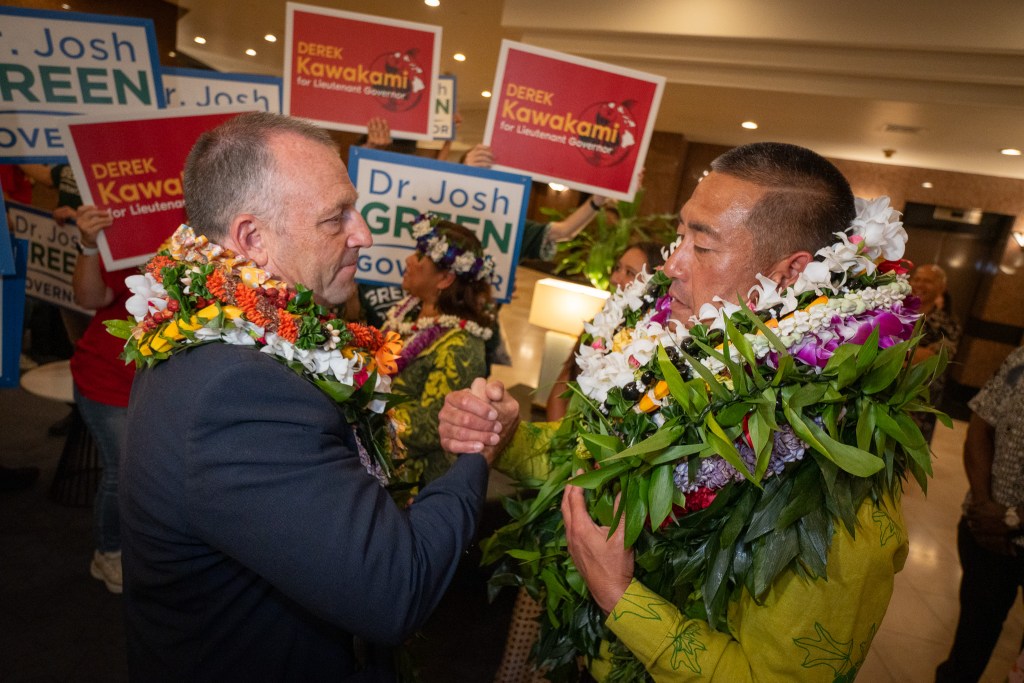 Gov. Josh Green and Kauaʻi Mayor Derek Kawakami clasp hands at Kawakami's primary election watch party in Honolulu August 8, 2026. Kawakami won the LG primary handily.