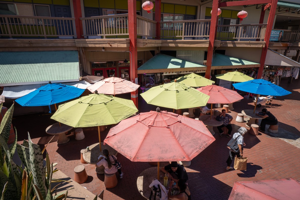 Umbrellas cast welcome shade at Maunakea Marketplace August 12, 2026. Aemarie Bracks died close by. (Craig Fujii/Civil Beat/2026)