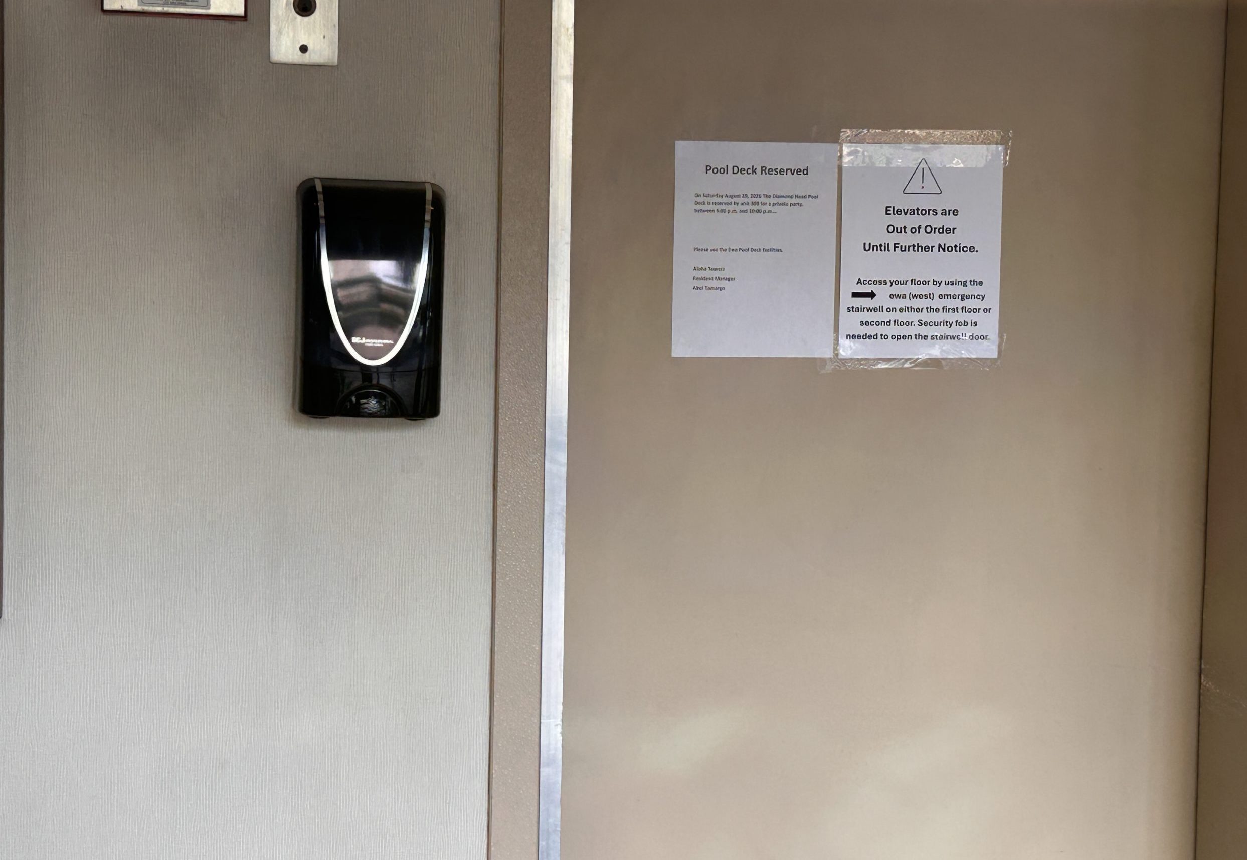 Brown elevator door with paper sign stuck on with tape saying elevators are out of service until further notice.