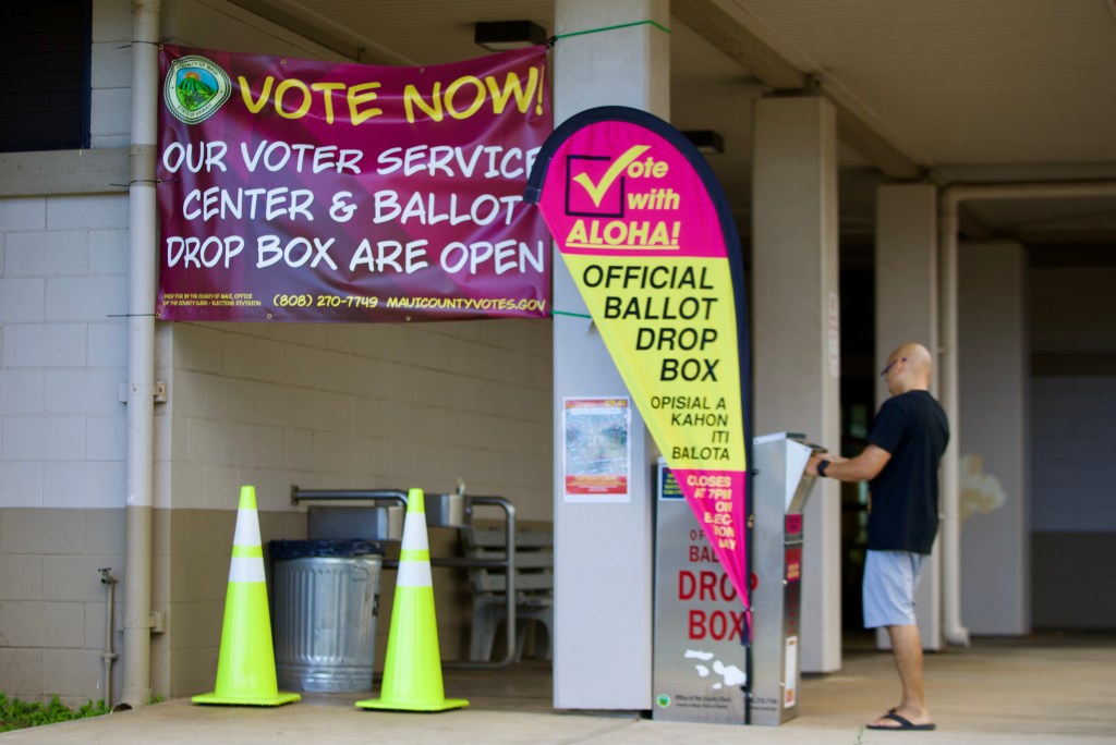 A voter places his ballot in the official drop box in front of the Velma McWayne Santos Community Center Saturday afternoon in Wailuku.