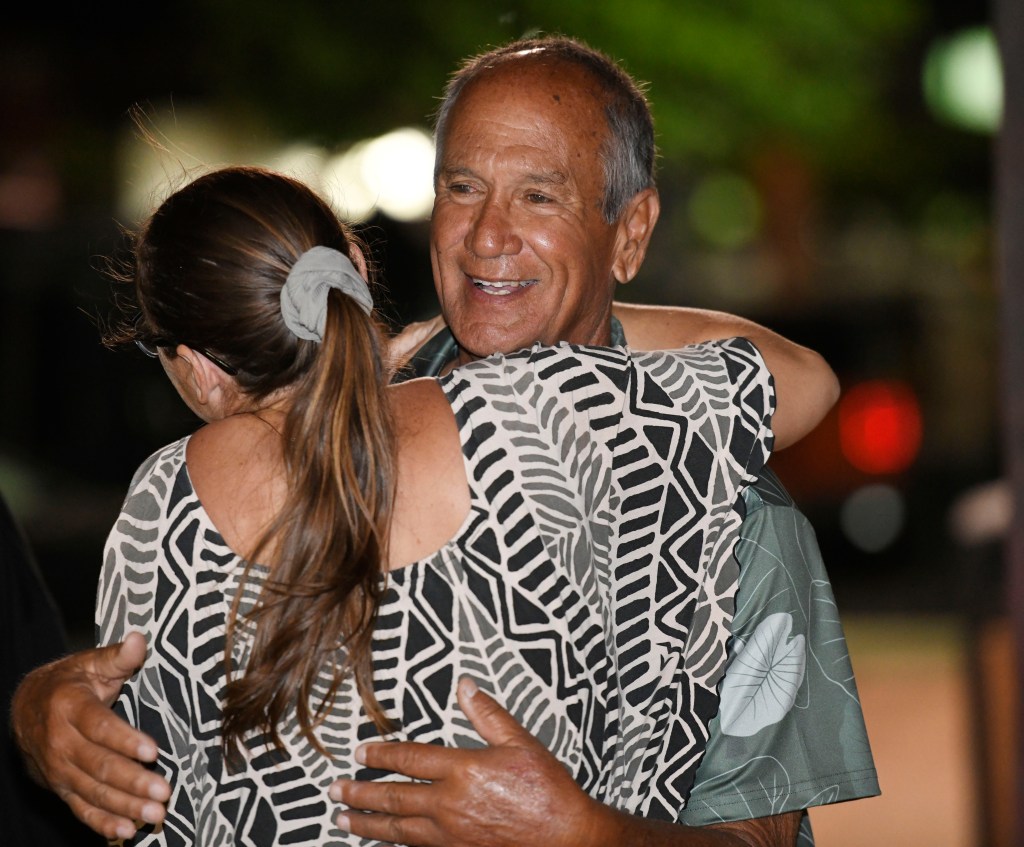 Maui County Council candidate Bobby Pahia receives a hug Saturday night in Kahului.