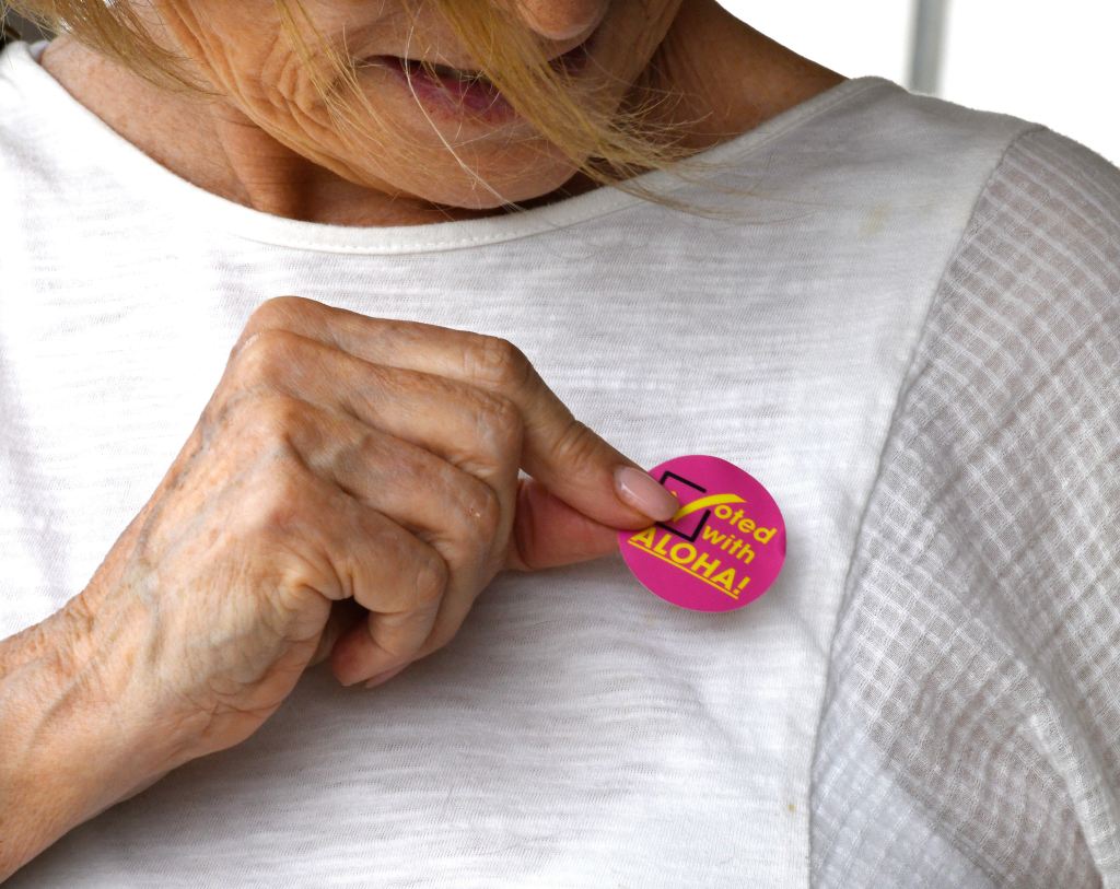 Makawao's Iris Nola puts a sticker on her blouse after voting in person Saturday morning at the Voter Service Center at Velma McWayne Santos Community Center in Wailuku. Photo by Matthew Thayer