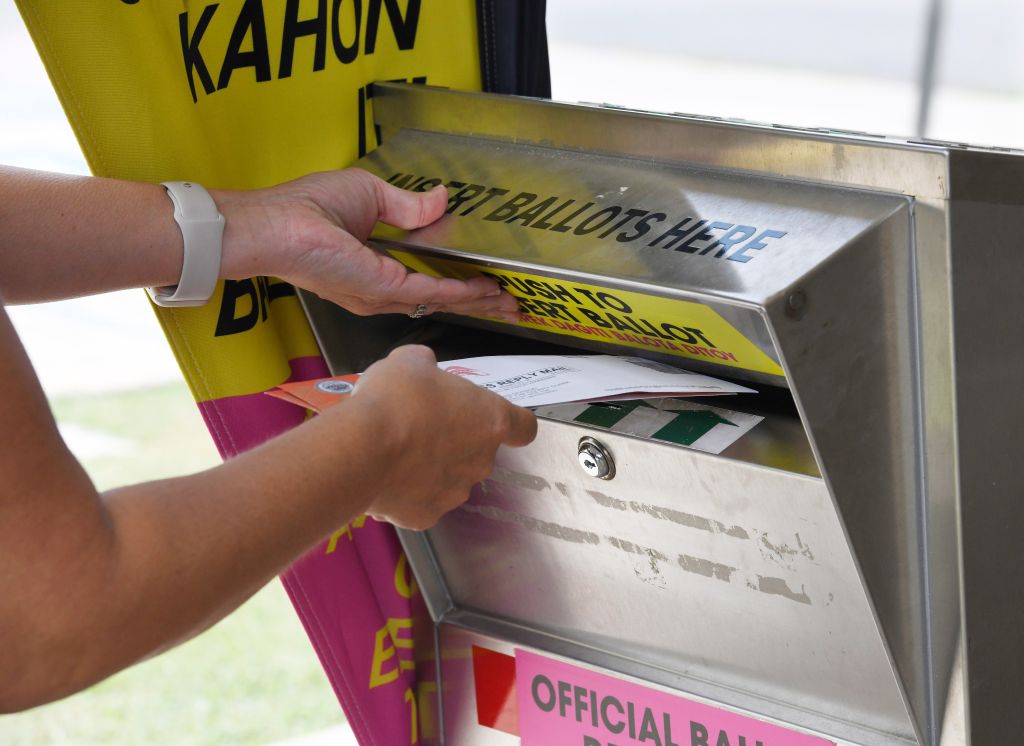 A voter places a pair of a ballots in an official ballot drop box at the Velma McWayne Santos Community Center Saturday morning in Wailuku. Photo by Matthew Thayer