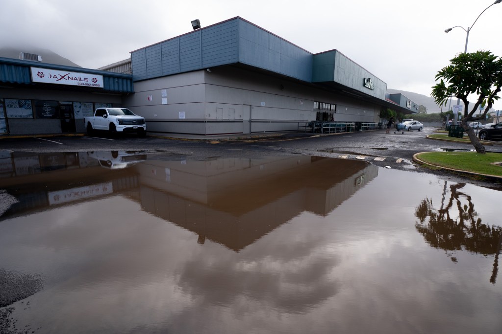 The Sack N Save in Nānākuli is reflected in a large puddle Sept. 8, 2026. Hurricane Lowell brought rainfall and heavy surf to Oʻahu overnight. (Craig Fujii/Civil Beat/2026)