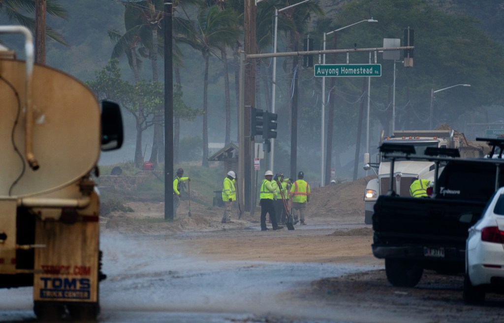 Workers cleared sand from a stretch of Farrington Highway Sept. 8, 2026. Hurricane Lowell pushed surf onto the thoroughfare overnight. (Craig Fujii/Civil Beat/2026)