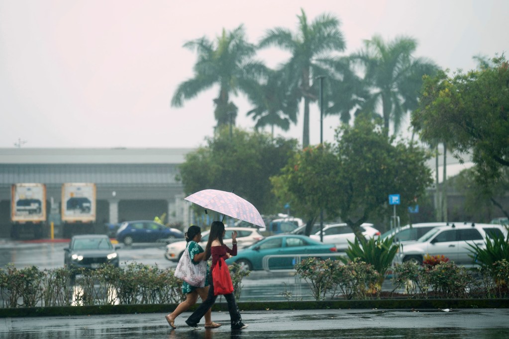 Shoppers walk through a parking lot as Hurricane Nolo’s outer bands reach Hawaiʻi Island Saturday, Sept. 26, 2026, in Hilo. (Kevin Fujii/Civil Beat/2026)