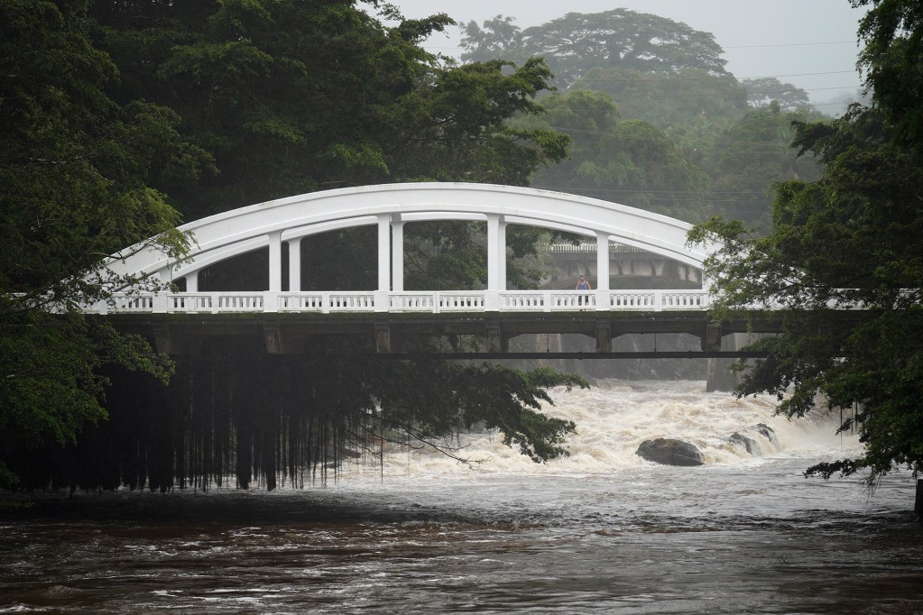 A man stops on the Puʻueo Bridge to look at the Wailuku River as the outer bands of Hurricane Nolo reaches Hawaiʻi Island Saturday, Sept. 26, 2026, in Hilo. (Kevin Fujii/Civil Beat/2026)