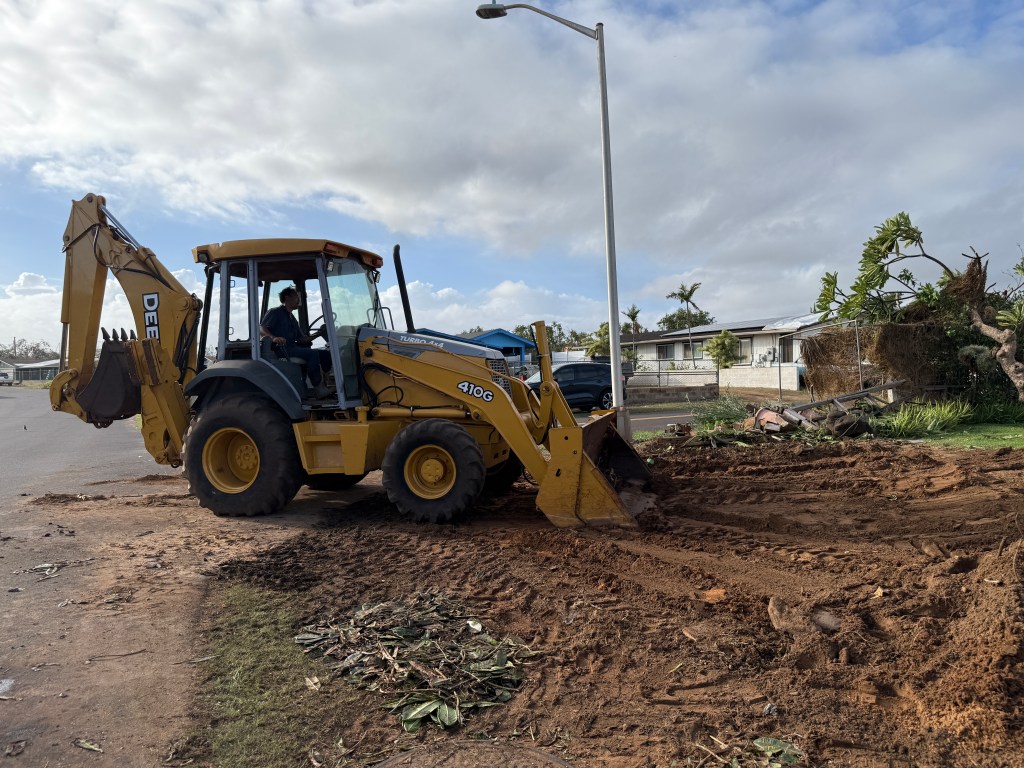 Kekaha farmer Kelsey Hesapene cleaned up his yard after his plumeria tree fell on his old wooden fence. He had just bought a backhoe for the farm. (Noelle Fujii-Oride/Civil Beat/2026)