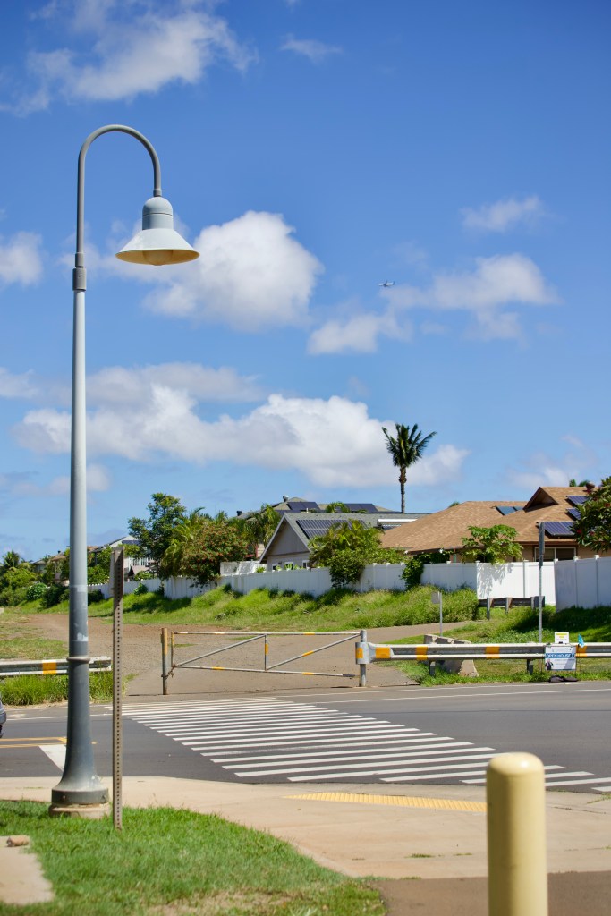 The road leading up to the site offered a glimpse of what is envisioned for the future — streetlights, plumeria trees and pathways for pedestrians and cyclists. The passageway ends abruptly at a metal gate, on the other side of which is a dusty, uneven trail.