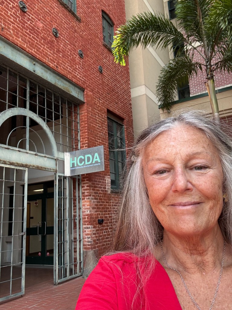 Lynda Lydon a Honuakaha resident, in front of the adjoining headquarters of the Hawaiʻi Community Development Authority.